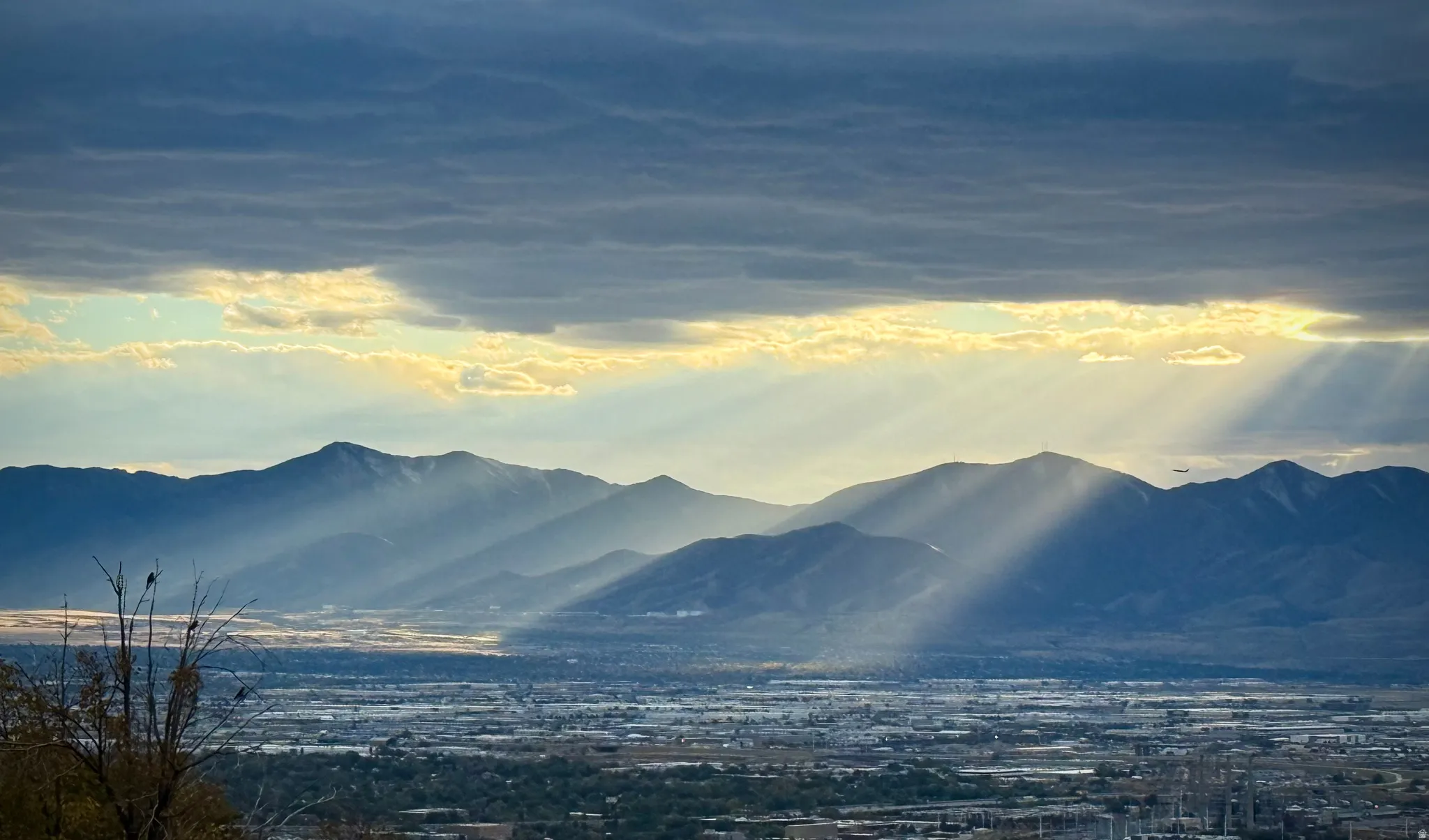 Expansive mountain backdrop with a visible cityscape