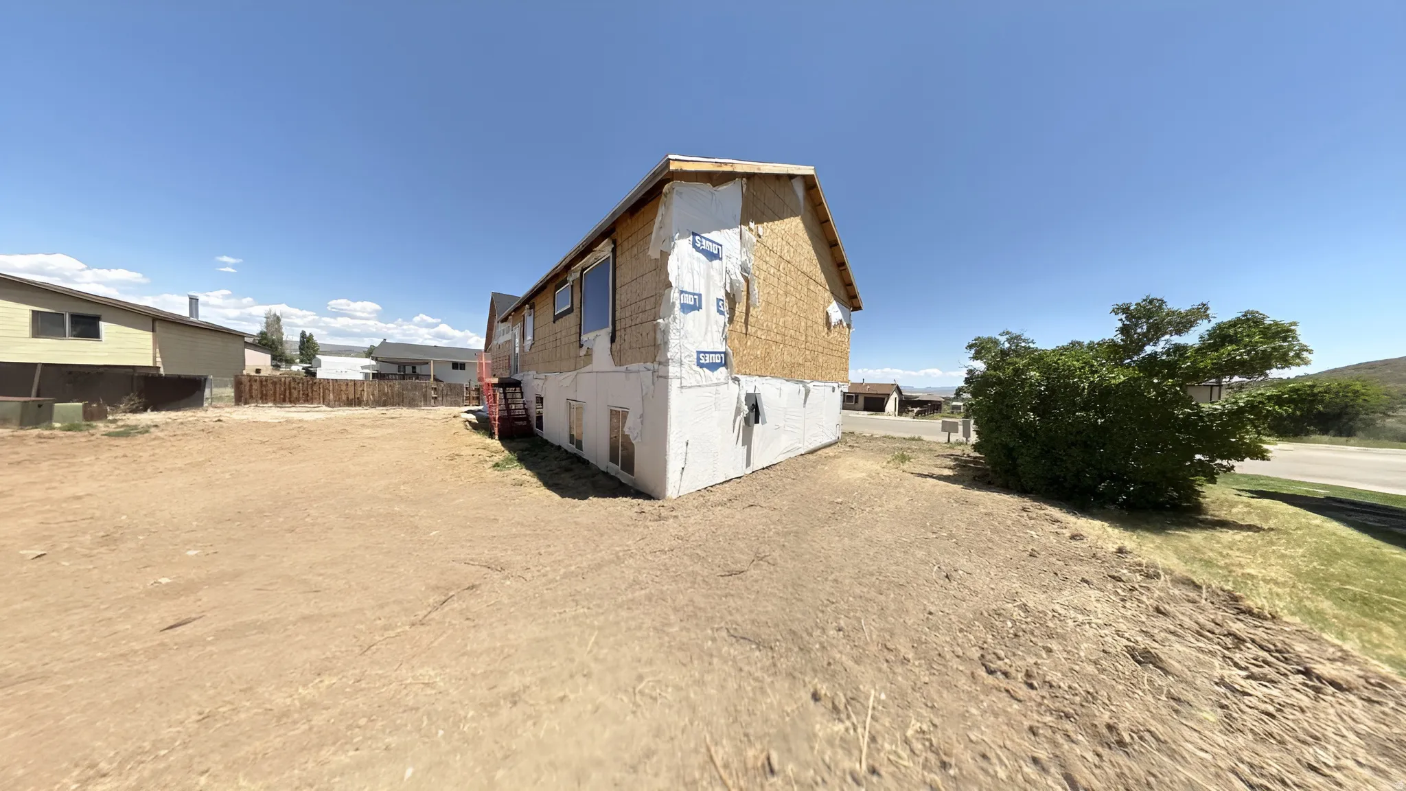 Structure under construction with exposed sheathing and a concrete foundation
