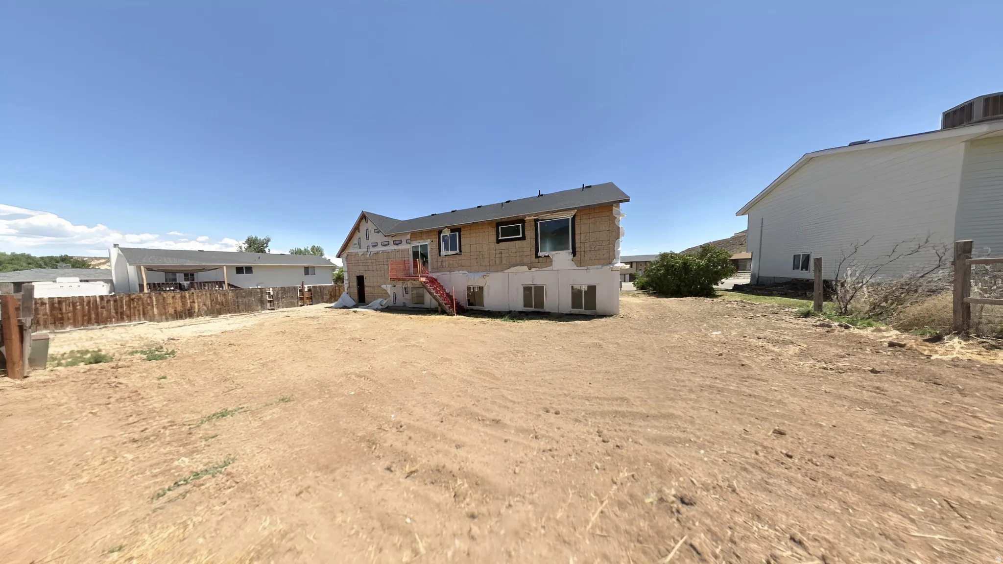 Rear exterior elevation featuring a wood-frame construction with new roof and visible window openings