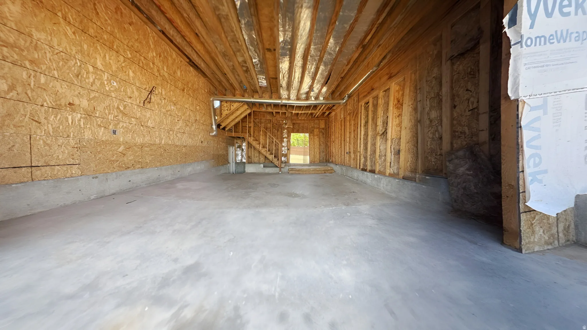 Spacious, unfinished basement with concrete slab flooring and exposed wood framing