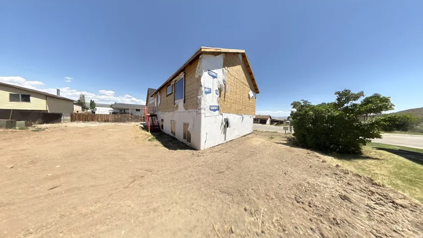 Structure under construction with exposed sheathing and a concrete foundation