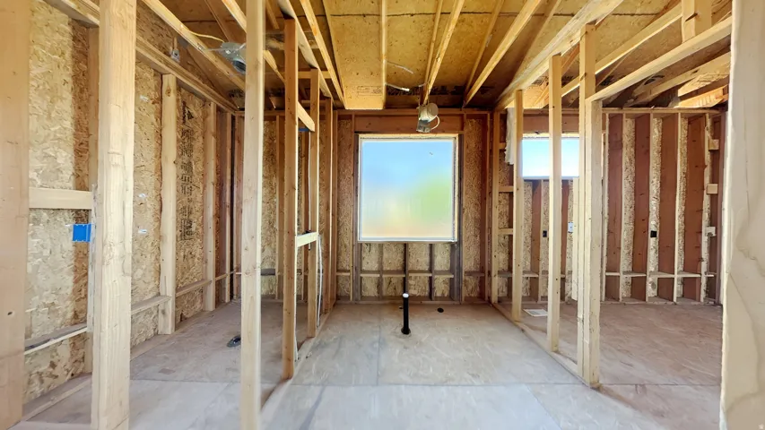 Interior framing showcasing a window opening, exposed wooden studs, oriented strand board (OSB) sheathing, and visible subflooring