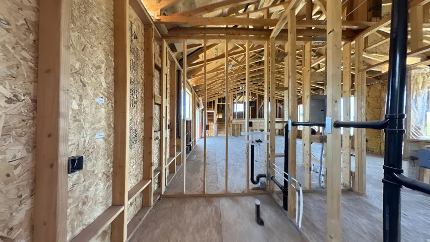 Interior framing details showcasing structural wood elements and plumbing rough-ins