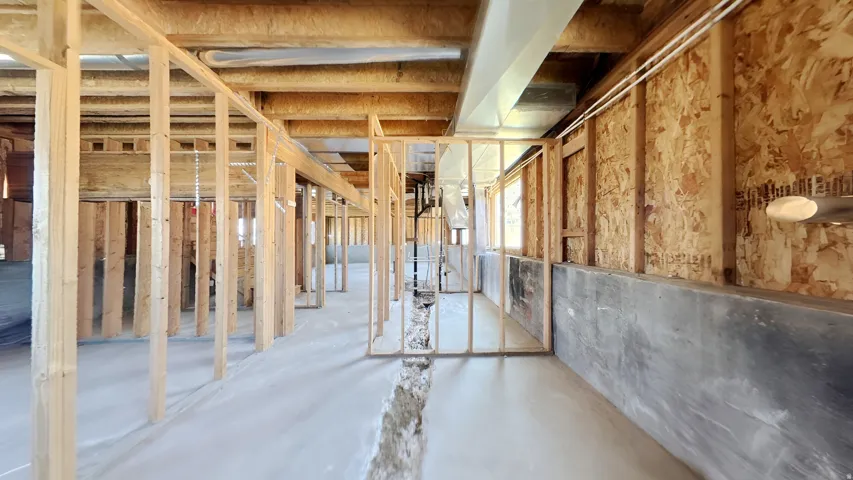 Unfinished basement featuring extensive wood framing, exposed ceiling joists, concrete flooring, and visible ductwork