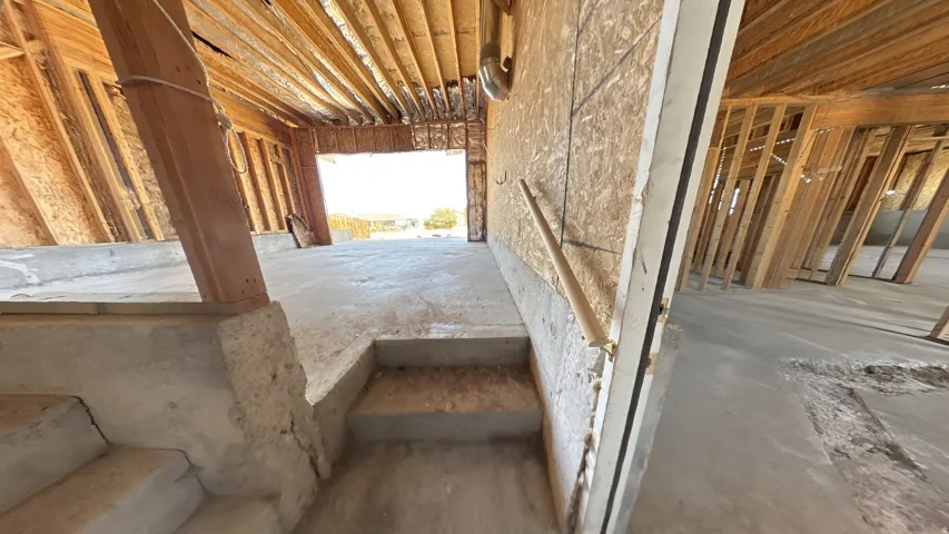 Unfinished interior featuring concrete flooring and exposed wood framing