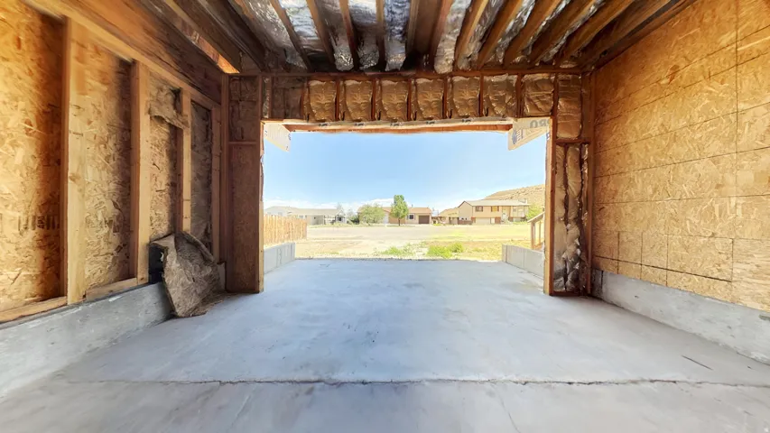 Unfinished interior space featuring exposed wood framing, concrete flooring, and visible insulation