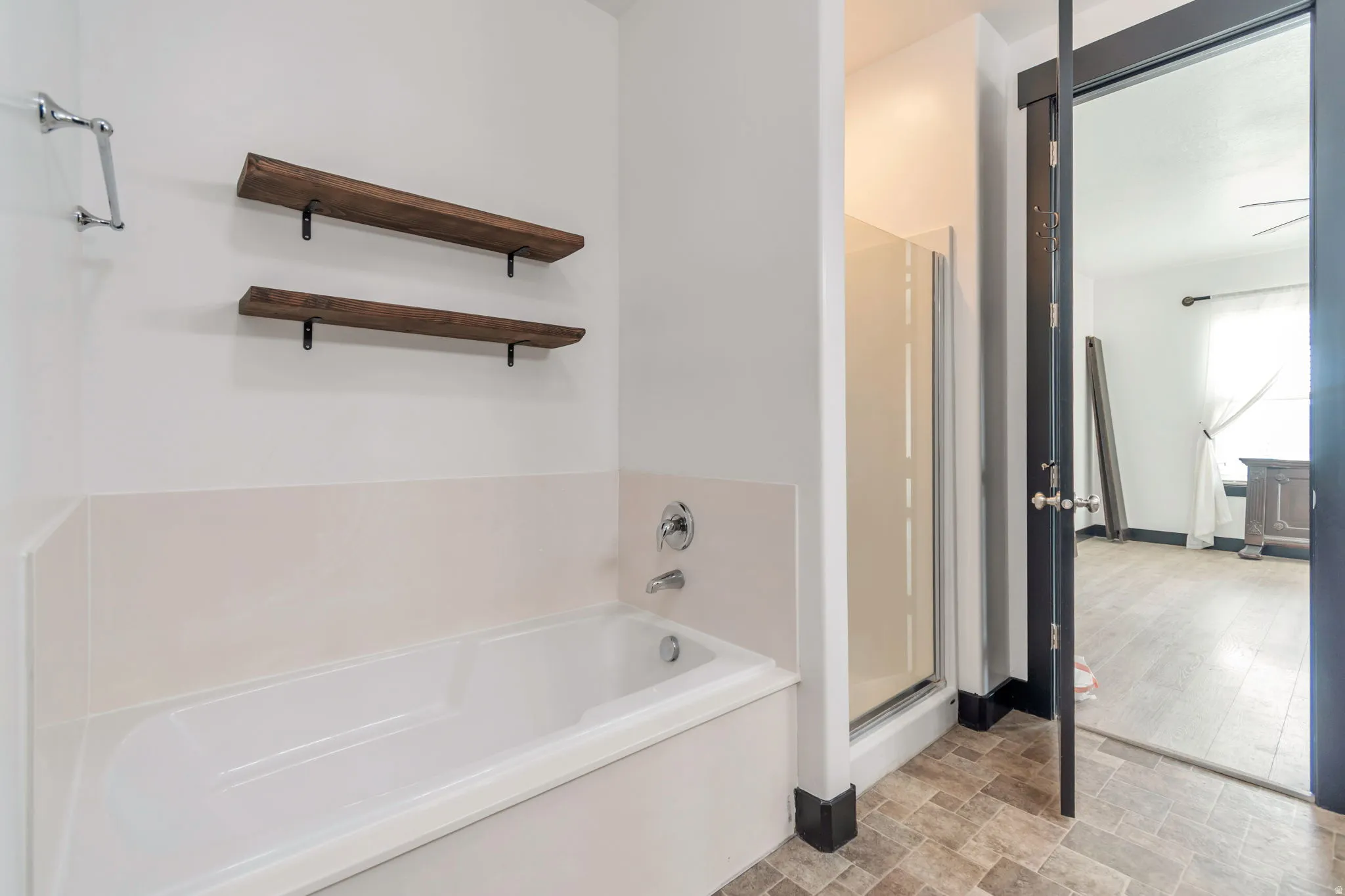 Soaking tub with chrome fixtures and light-toned surround