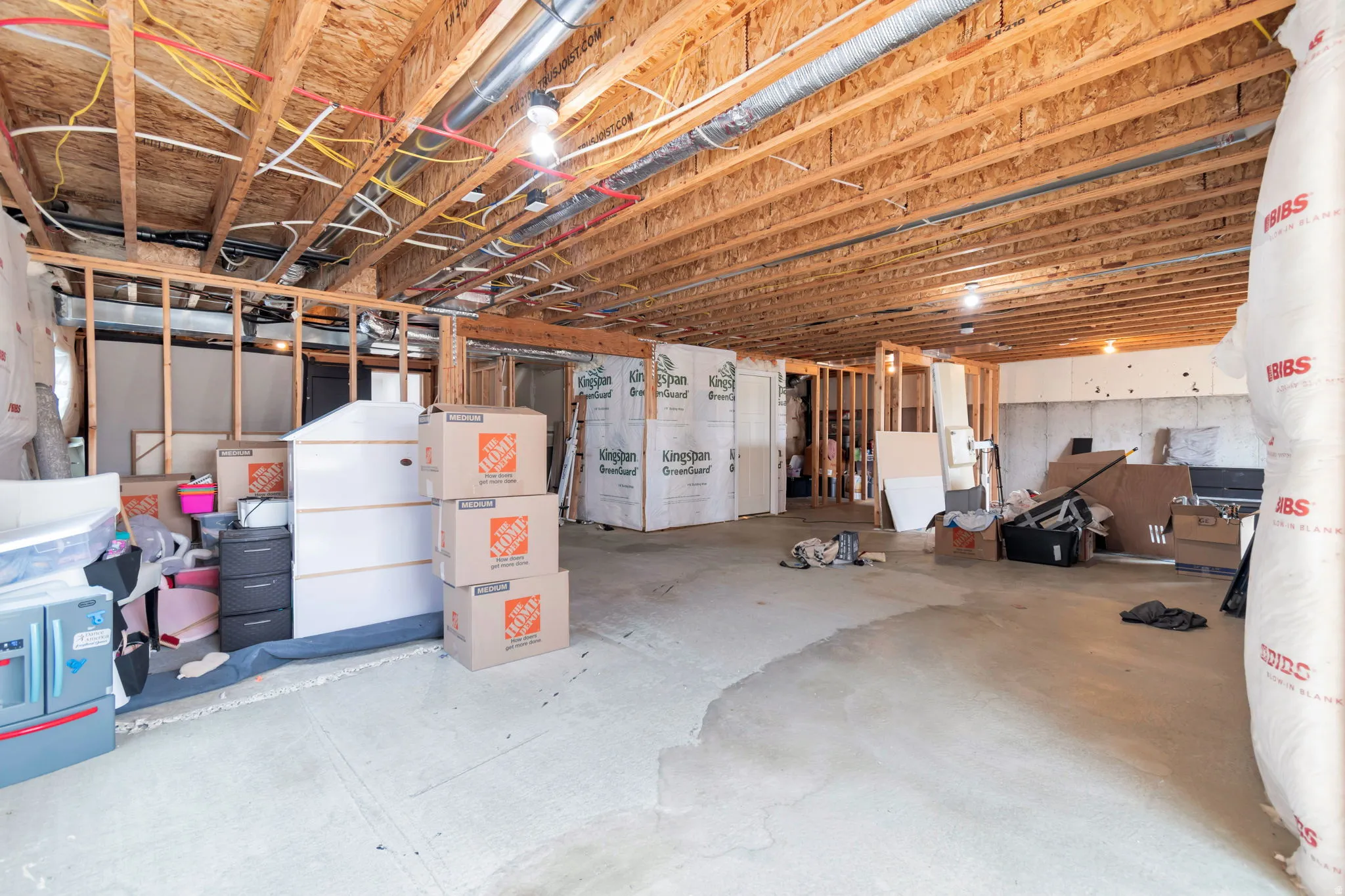 Unfinished basement featuring exposed wood joists and concrete flooring