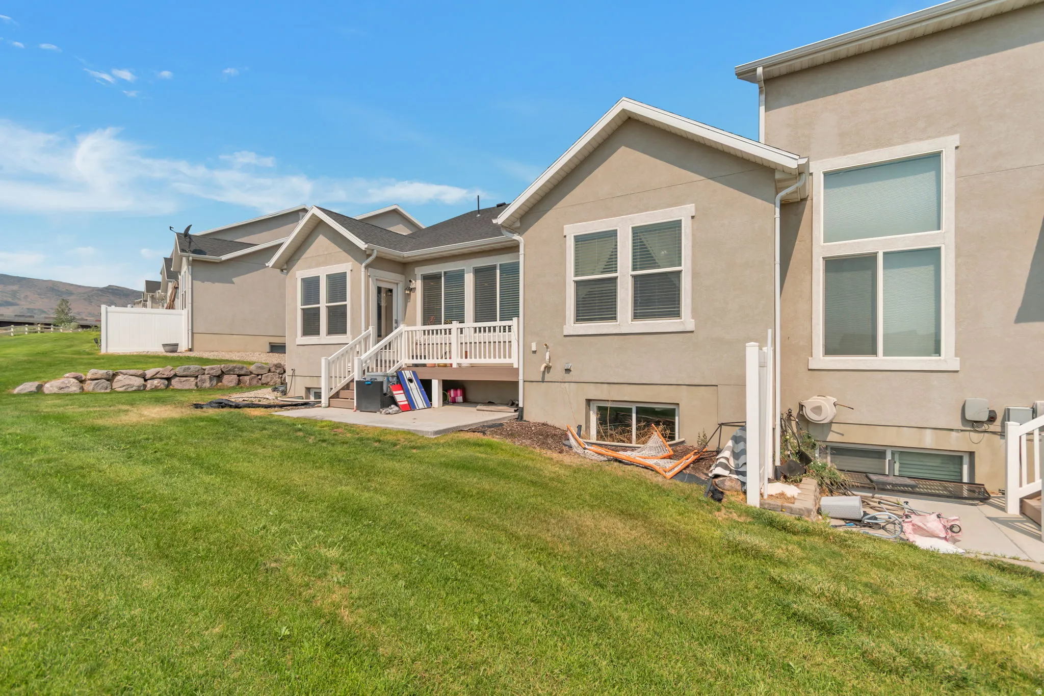 Expansive green lawn with a tiered rock retaining wall
