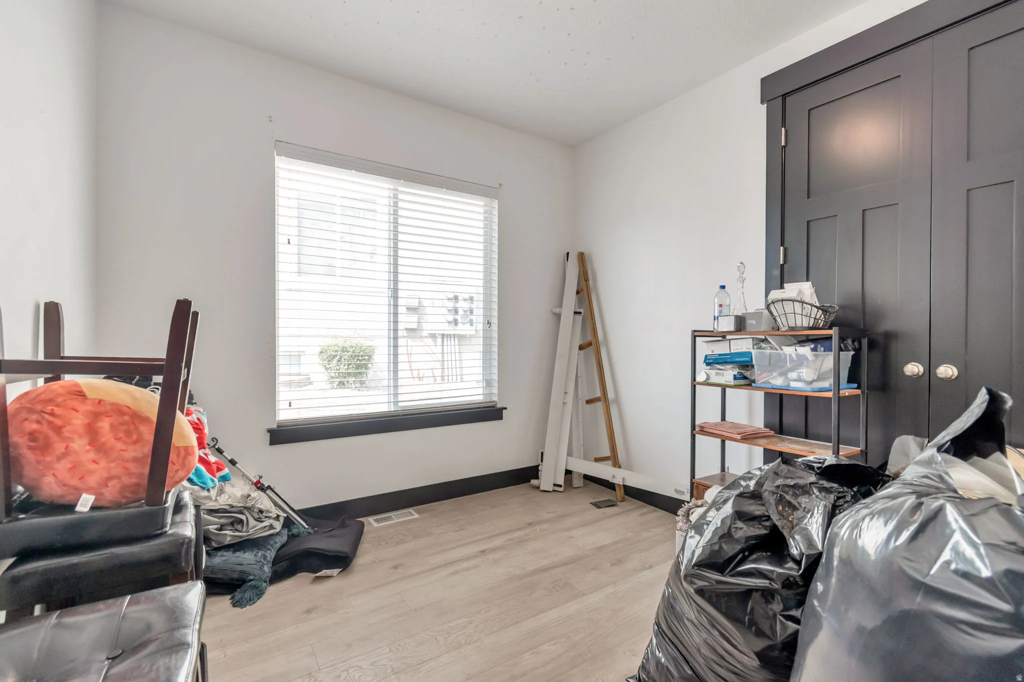 Room featuring light wood-finish flooring, white walls, and dark trim details