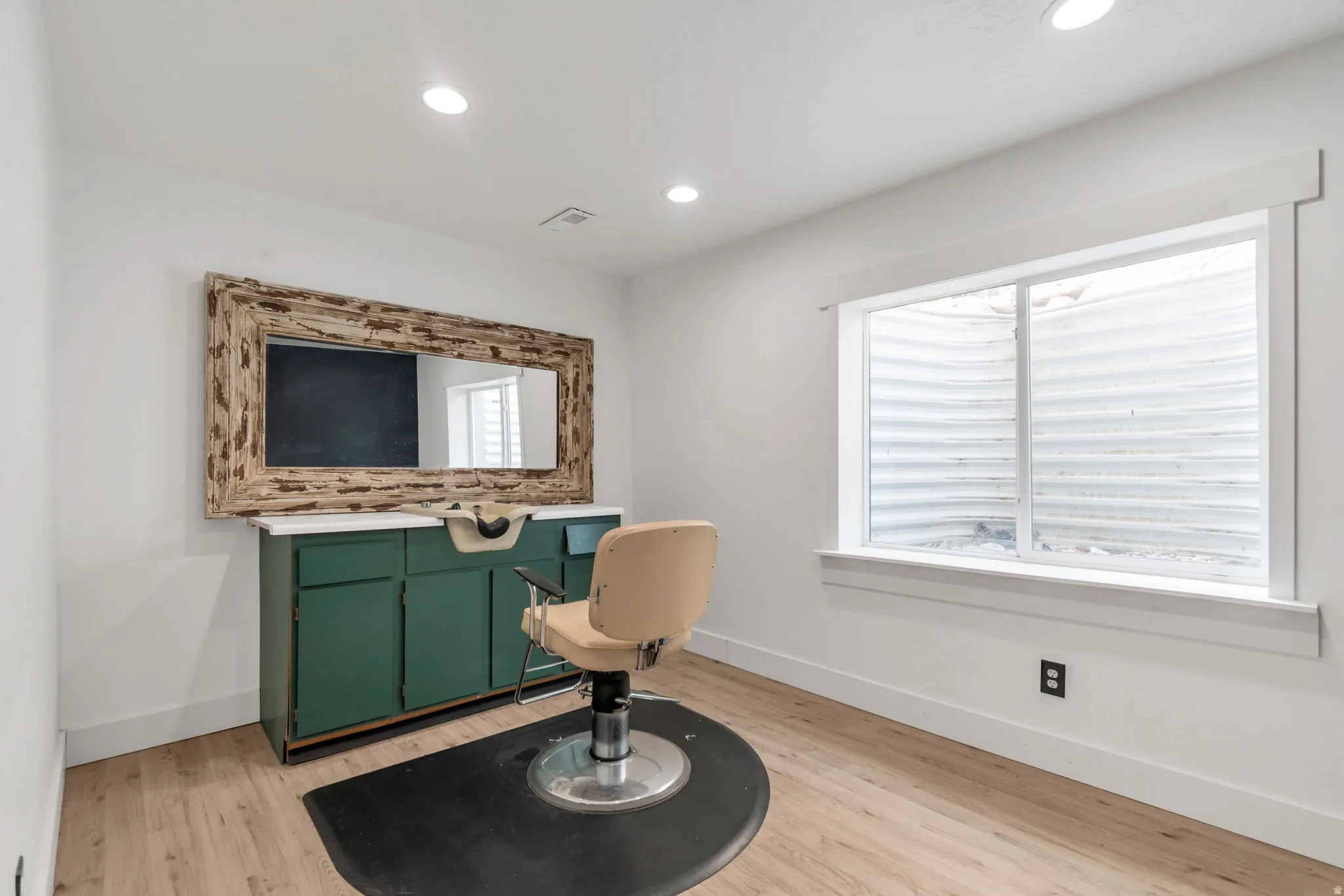 Dedicated room featuring recessed lighting, light wood-finish flooring, and a large window