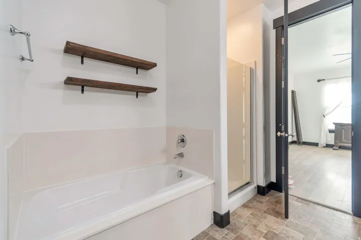 Soaking tub with chrome fixtures and light-toned surround