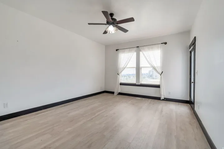 Room featuring wood-finish flooring, white walls, and dark trim