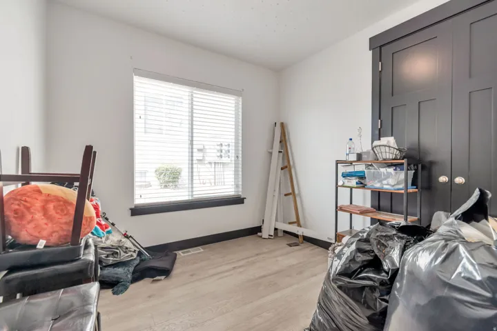 Room featuring light wood-finish flooring, white walls, and dark trim details