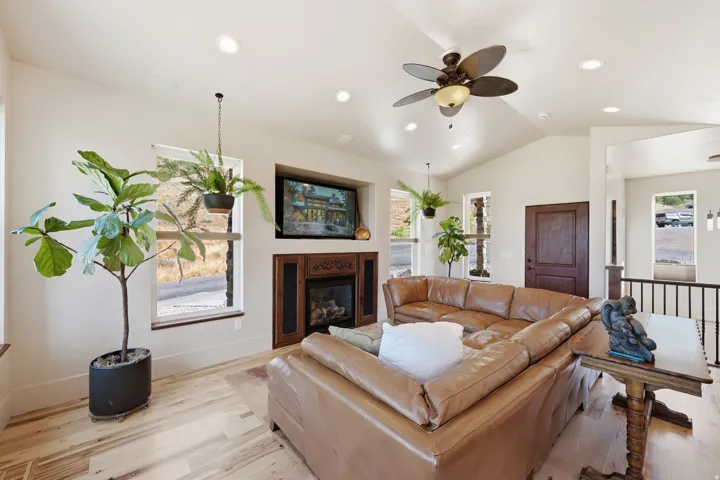Spacious living area featuring vaulted ceilings, recessed lighting, and wood-finish flooring