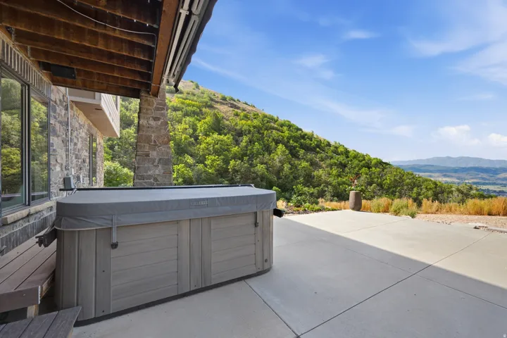 Outdoor spa with a protective cover situated on a concrete patio
