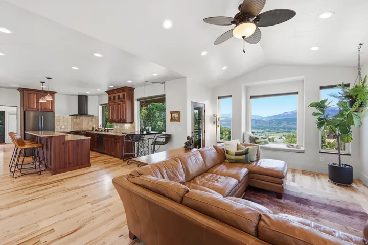 Open-concept living space with vaulted ceilings, recessed lighting, and wood-finish flooring