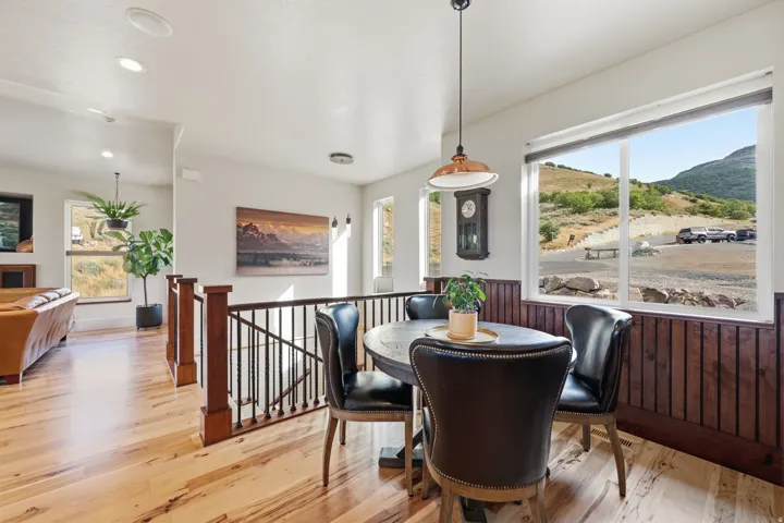 Dining area featuring wood-finish flooring, wainscoting, and a large window