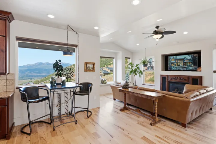 Open-concept living space with light wood-finish flooring, recessed lighting, and a vaulted ceiling