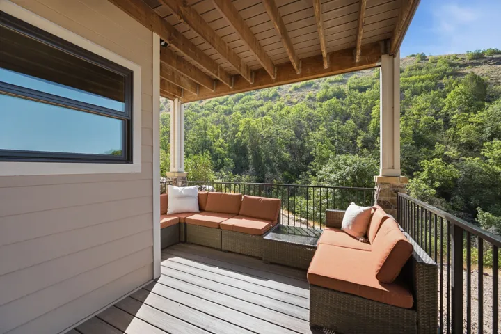 Spacious outdoor deck featuring composite decking, a sturdy railing, and an exposed wood ceiling