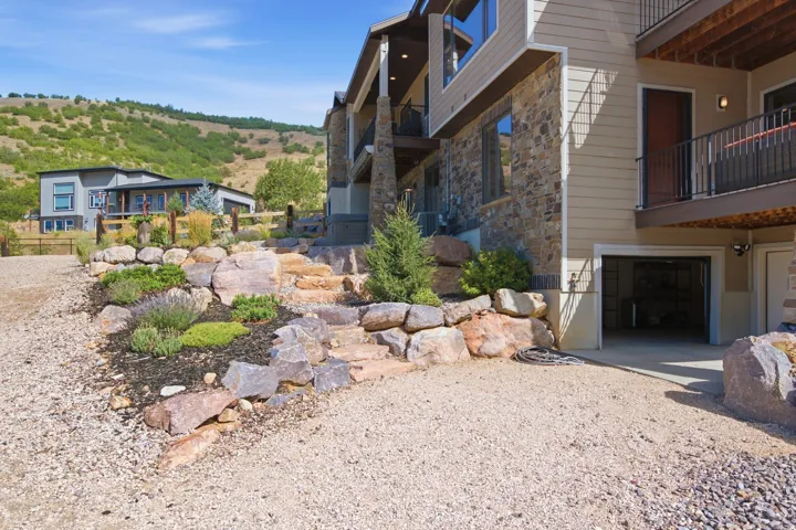 Stone and siding exterior with multiple balconies and an integrated garage
