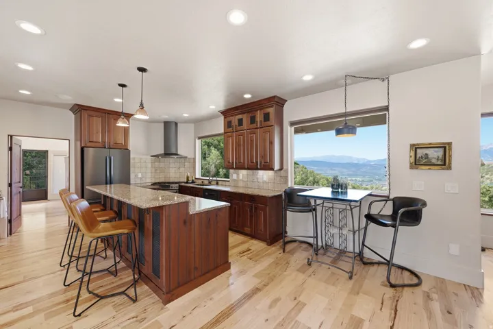 Kitchen featuring wood-finish flooring, recessed lighting, and a kitchen island with a granite countertop