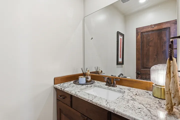 White countertop with grey and brown veining, under-mount rectangular sink, and oil-rubbed bronze faucet
