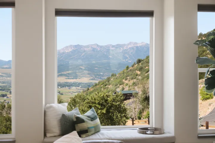 Expansive window framing panoramic mountain and valley scenery