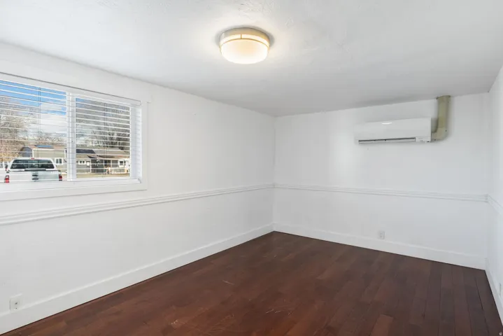 Bright interior space featuring wood-finish flooring, white walls, and an integrated mini-split system