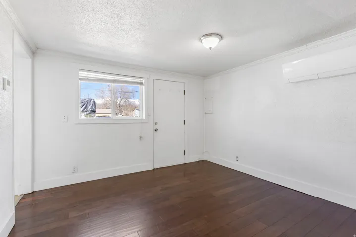 Room featuring dark wood-finish flooring, white walls, and a white ceiling with a flush-mount light fixture
