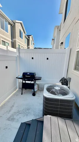 Private outdoor patio space featuring concrete flooring and white vinyl fencing