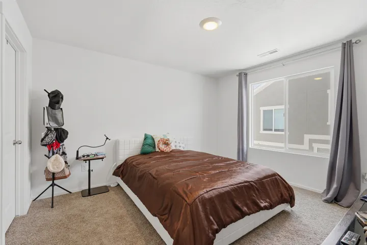 Spacious room featuring neutral carpeting, a large window, white walls, and a recessed ceiling light