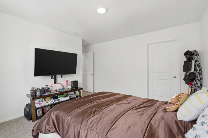 Bright interior space with white walls, carpeted flooring, and a flush-mount ceiling light fixture