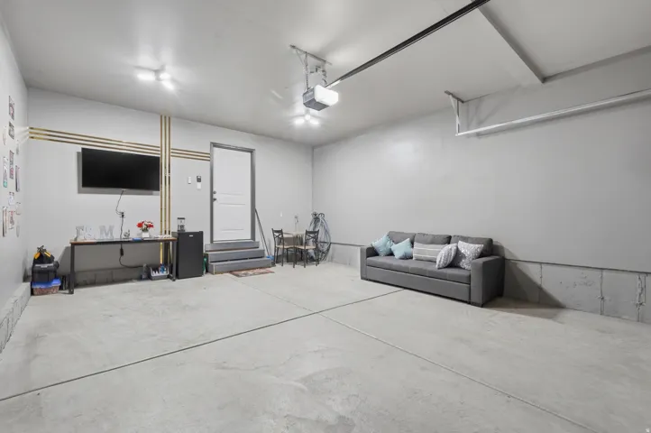Spacious garage featuring a concrete floor, painted walls, and an overhead garage door mechanism