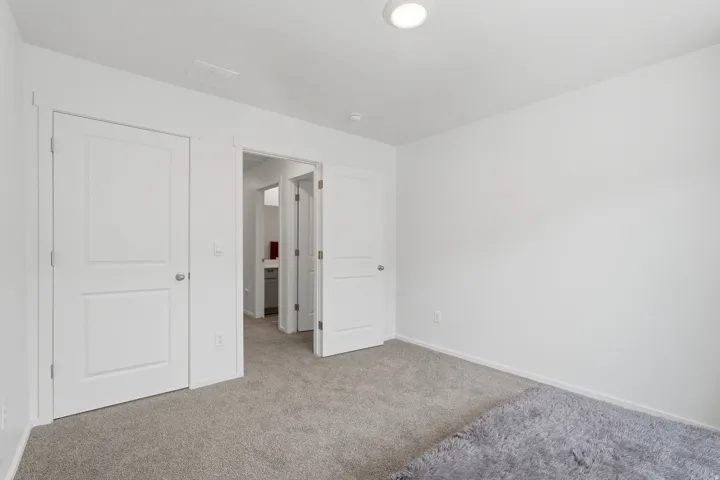 Carpeted room featuring white walls, white trim, and recessed ceiling lighting