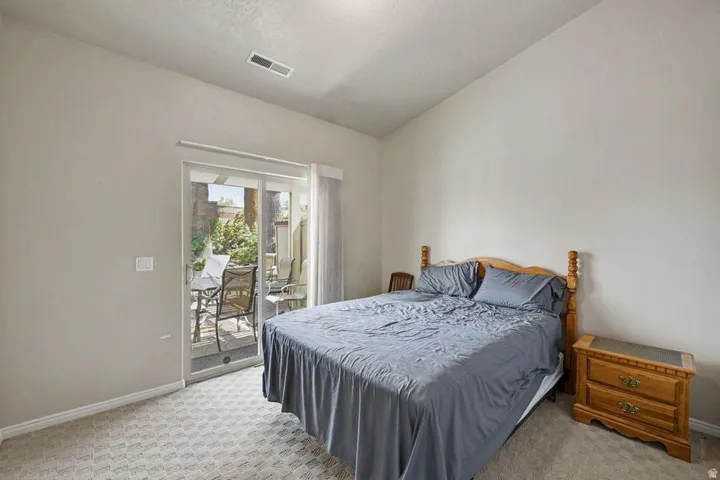 Bedroom with vaulted ceiling and patterned carpet