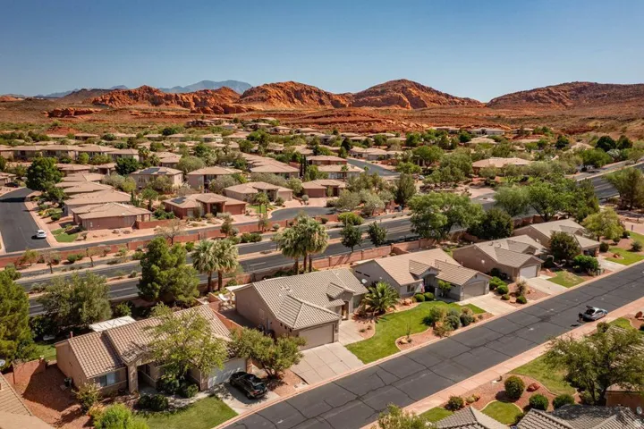 Residential area featuring single-story homes with tile roofs, paved streets, and mature landscaping