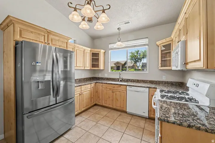 Kitchen featuring wood cabinetry, granite-look countertops, and stainless steel appliances
