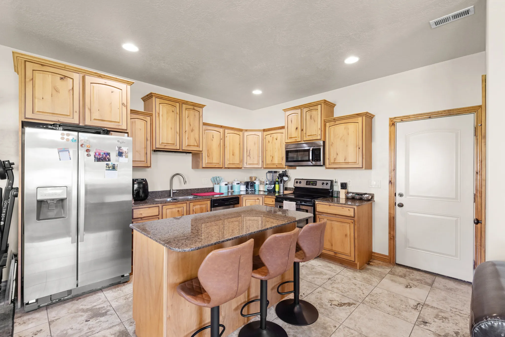 Kitchen featuring wood cabinetry, granite countertops, and stainless steel appliances