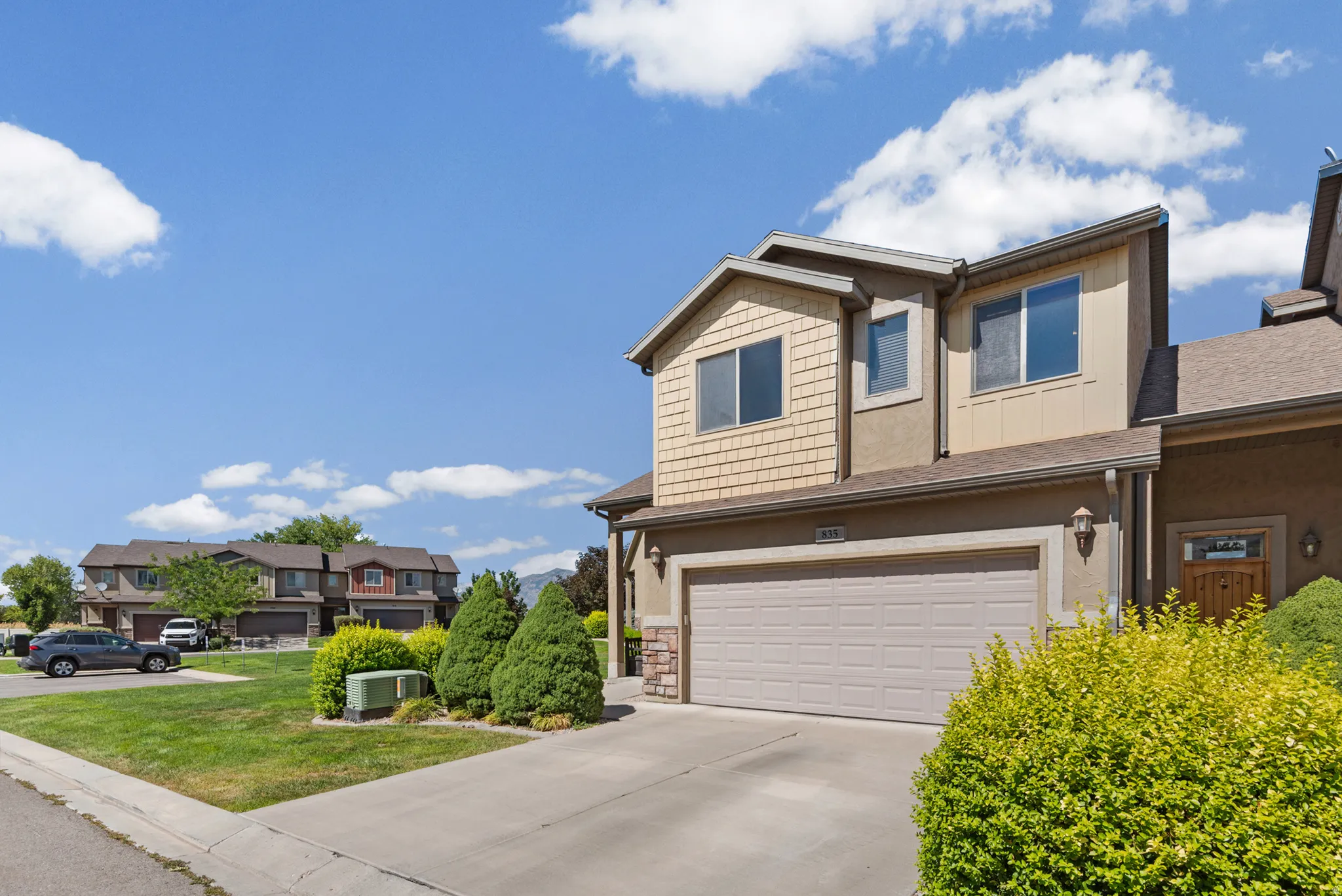 Multi-level stucco exterior featuring shake siding accents and a two-car garage