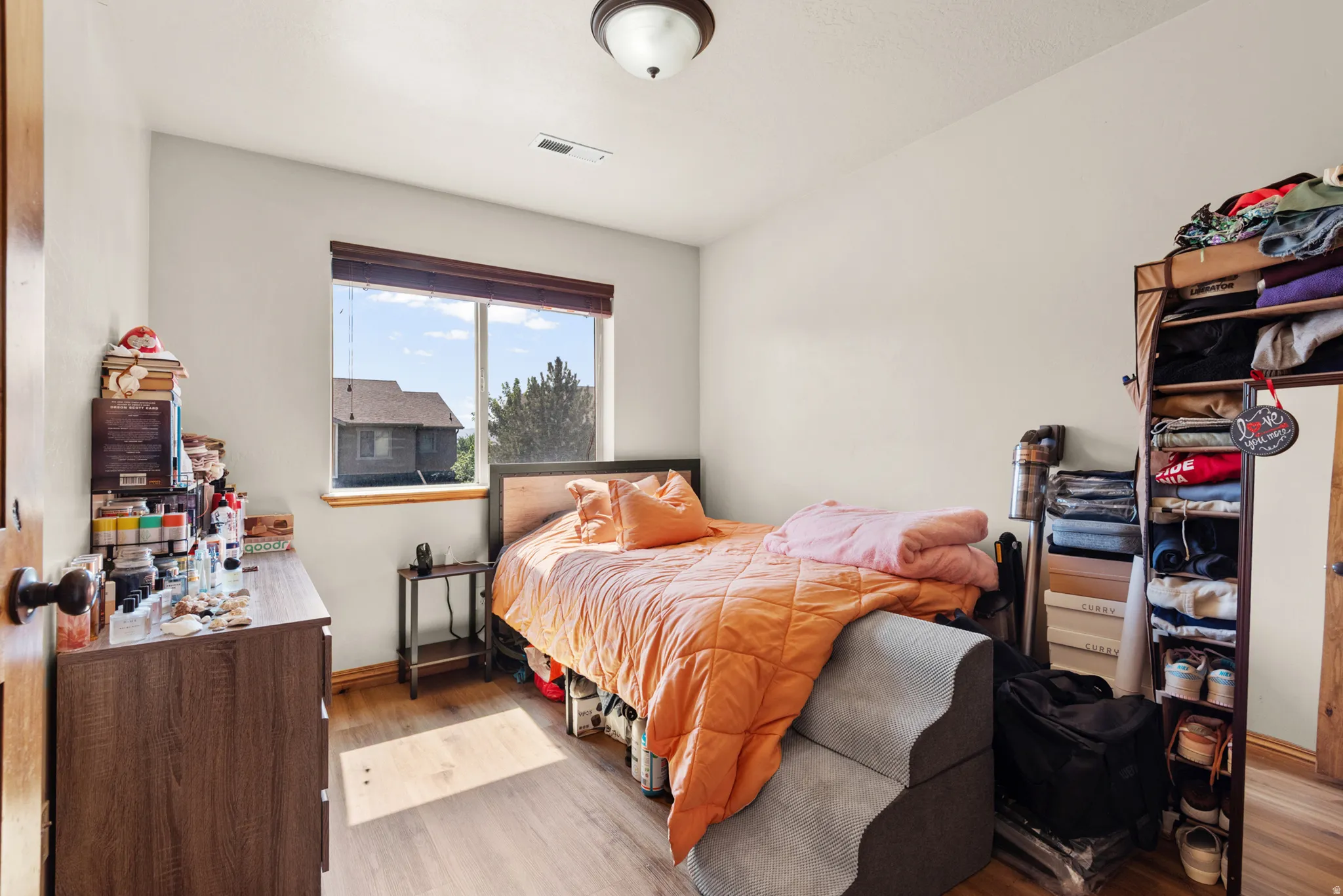 Bright room with wood-finish flooring, a double window featuring a dark wood sill and trim, and a ceiling-mounted light fixture