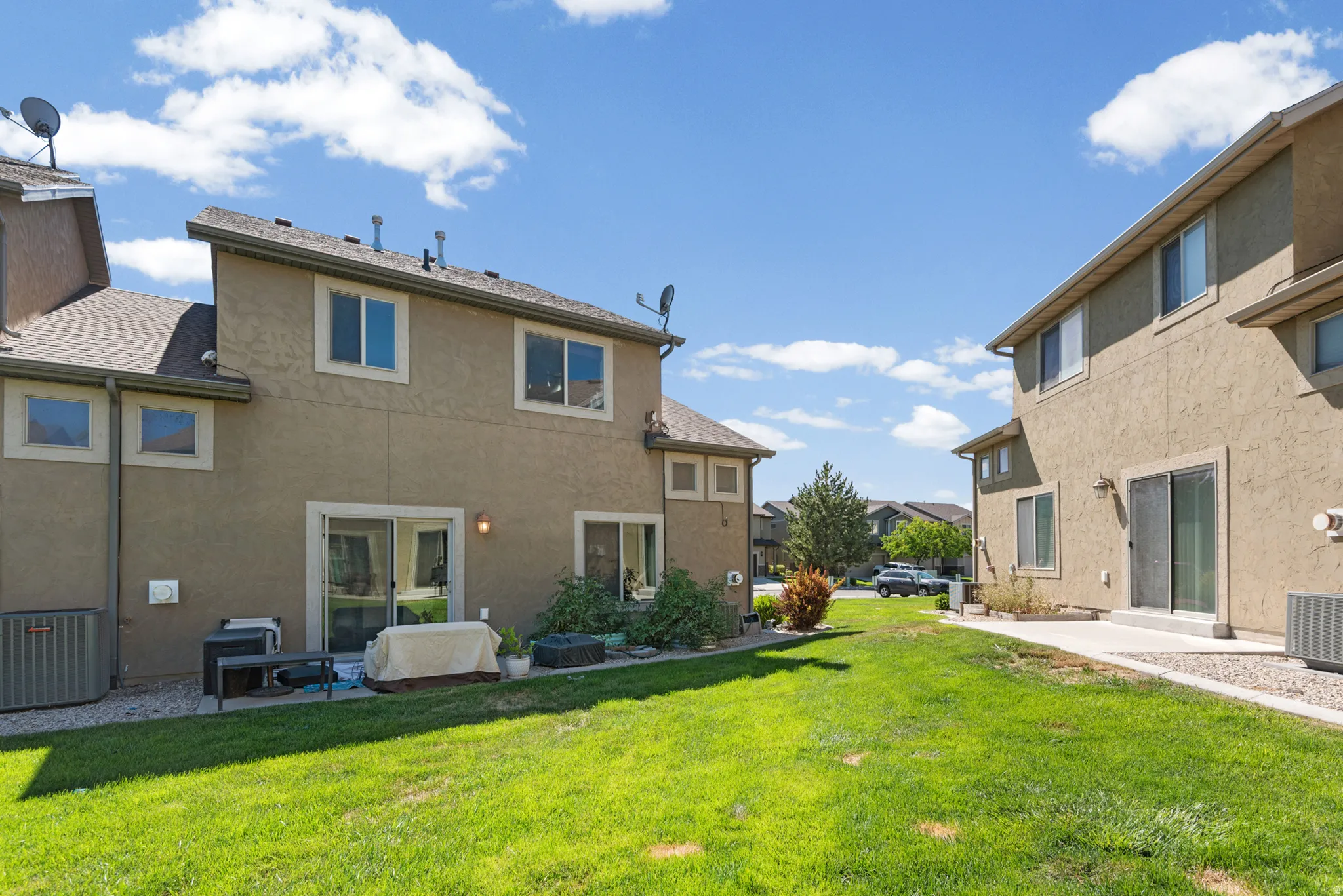 Rear exterior showcasing stucco siding and a pitched shingle roof