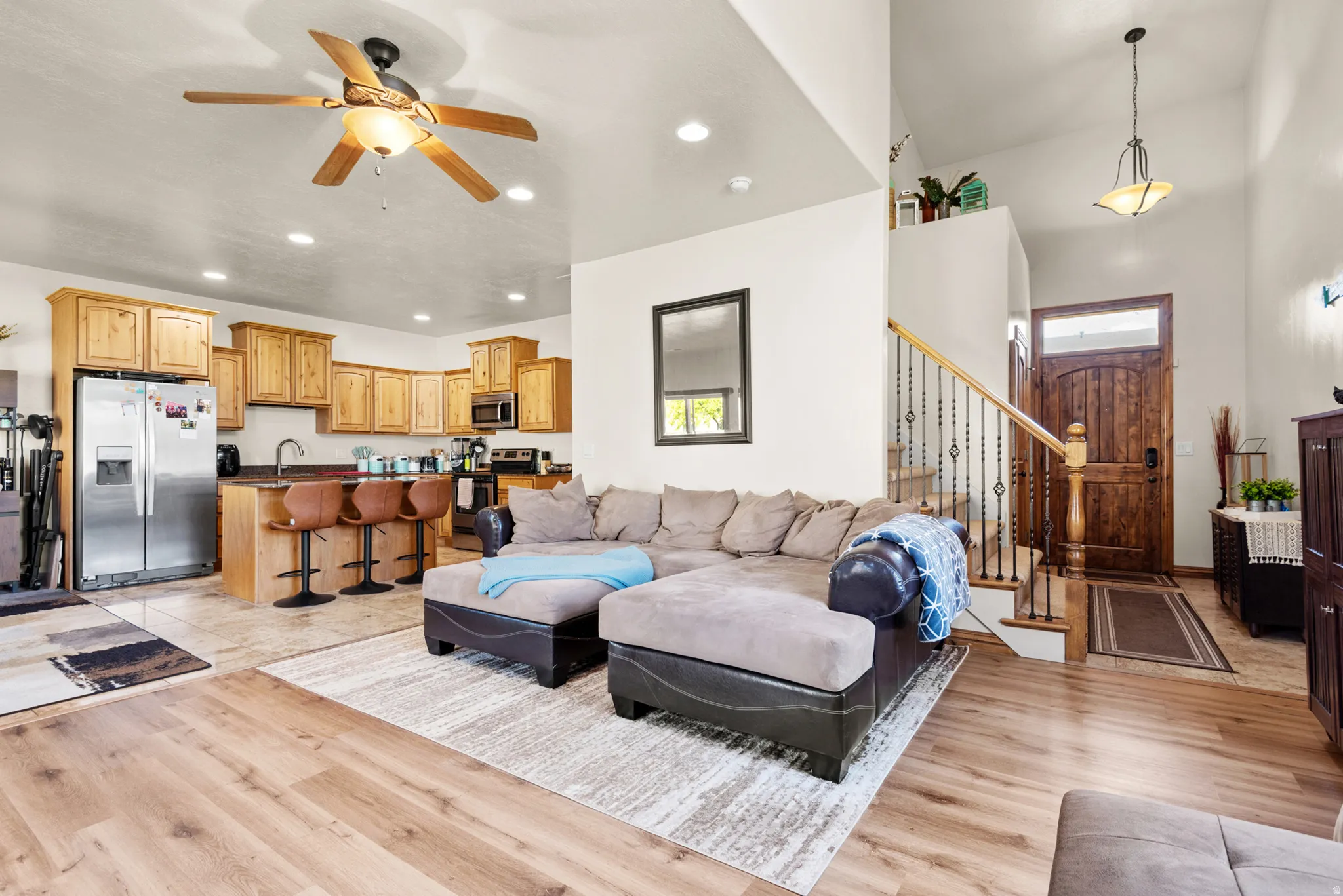 Open-concept living space featuring wood-finish flooring, recessed lighting, and a ceiling fan