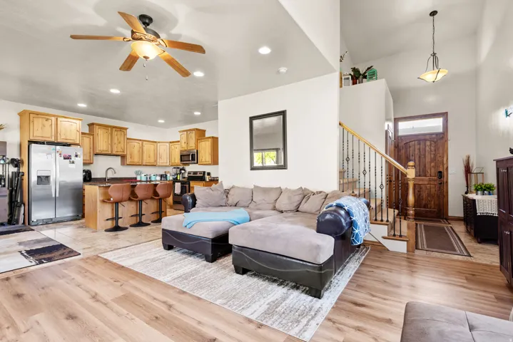 Open-concept living space featuring wood-finish flooring, recessed lighting, and a ceiling fan