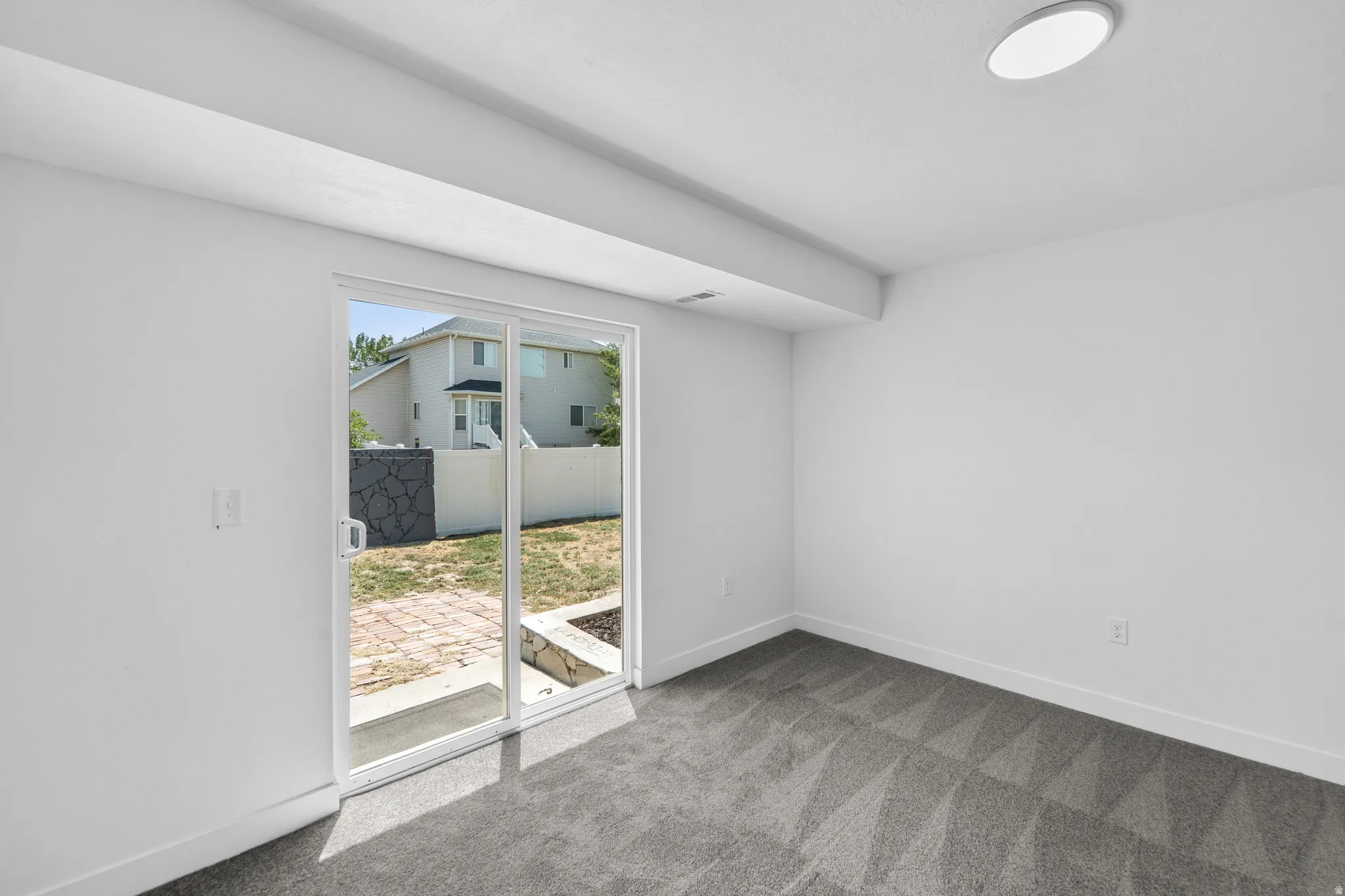 Room with a sliding glass door providing direct outdoor access