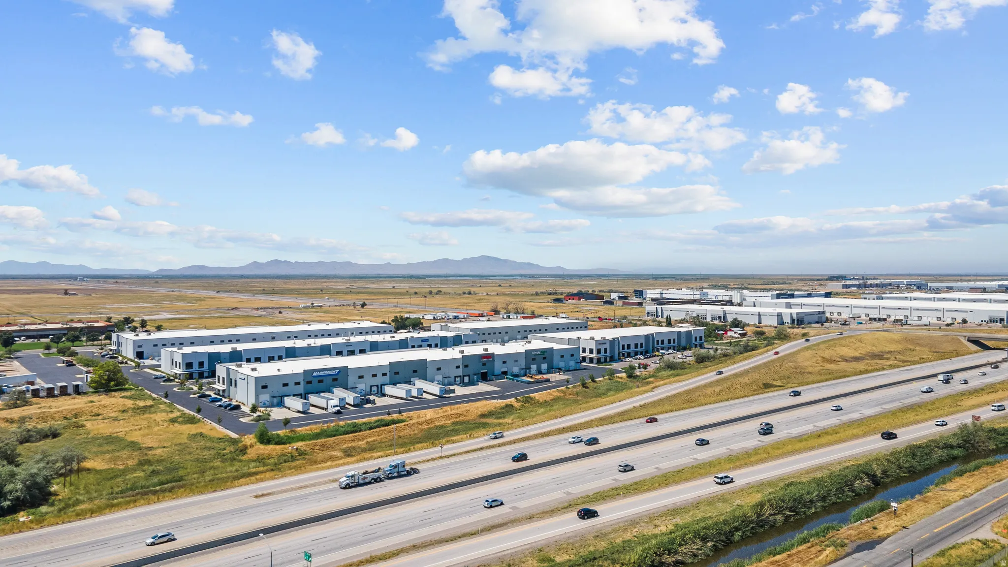 Industrial park featuring multiple buildings with dock-height loading doors, ample parking, and freeway frontage