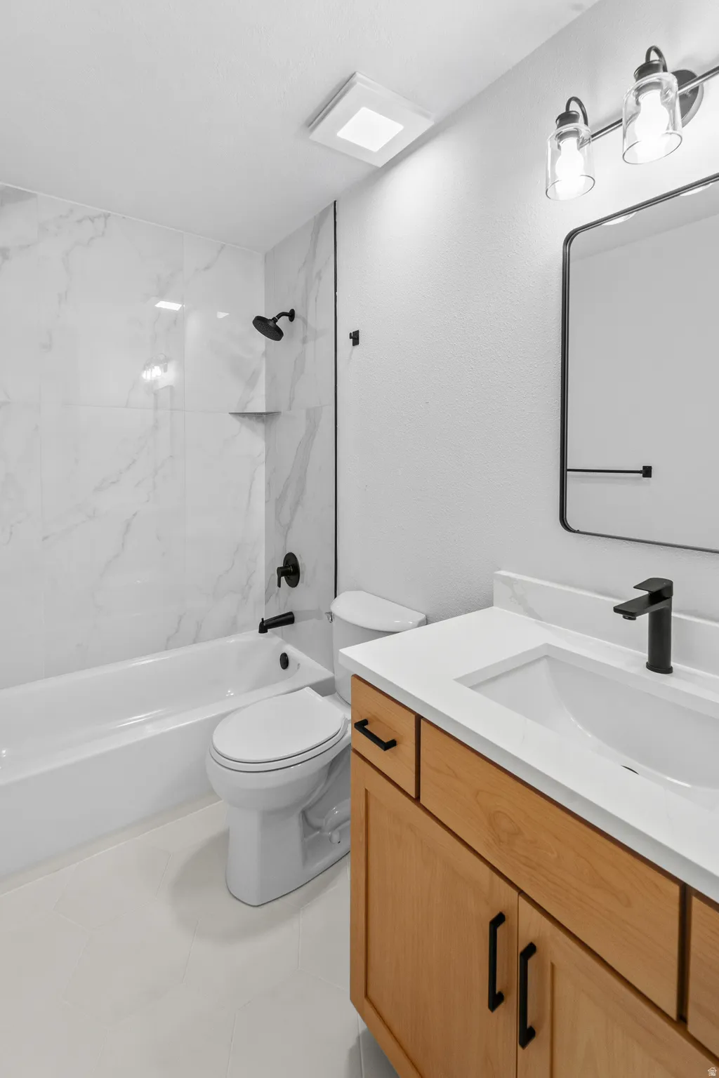 Bathroom featuring a light wood-tone vanity with a white countertop and integrated sink