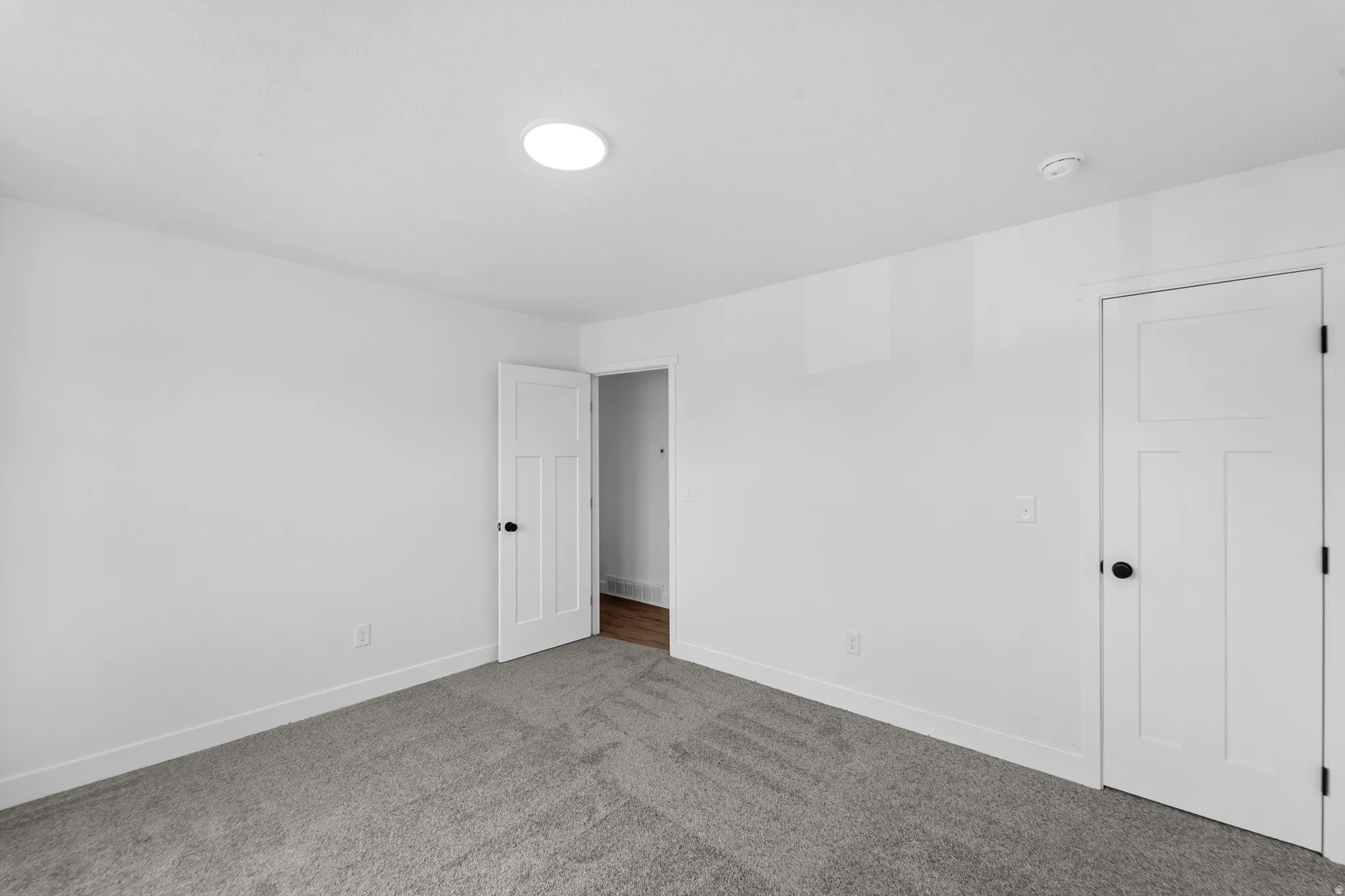 Carpeted interior space featuring white walls and white baseboards