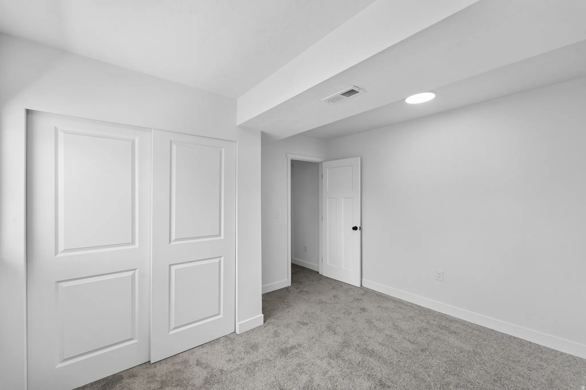 Room featuring light gray carpet flooring, white painted walls, and white trim