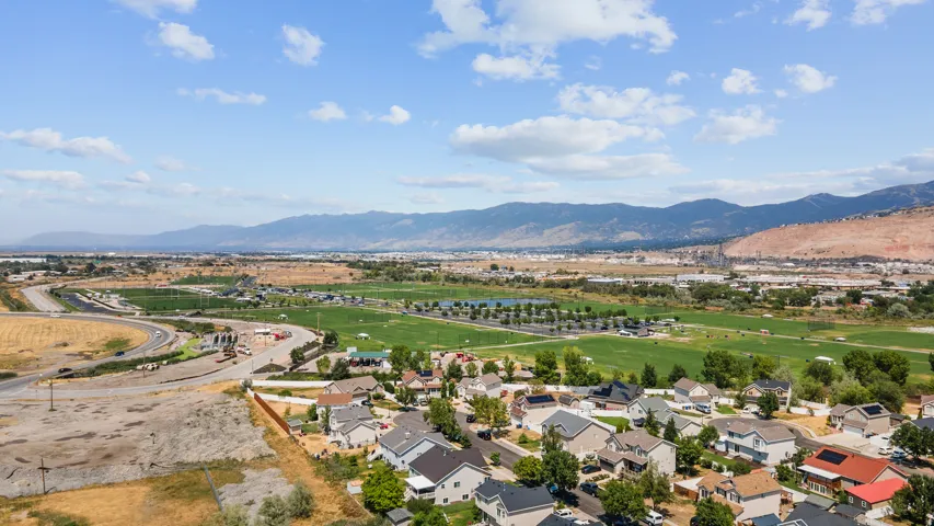 Aerial perspective showcasing a residential area with varied rooflines and surrounding green spaces
